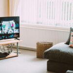 Chic and comfortable living room featuring a modern sofa, decorative pillows, and a TV streaming popular shows.