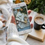 Top view of cozy winter setting with coffee, smartphone capturing a warm flat lay.