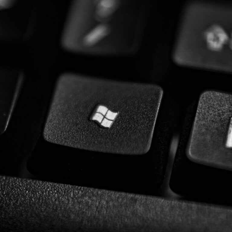 High-quality close-up of a Windows logo key on a black plastic keyboard.