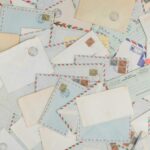 A collection of vintage airmail envelopes and postcards scattered with stamps.