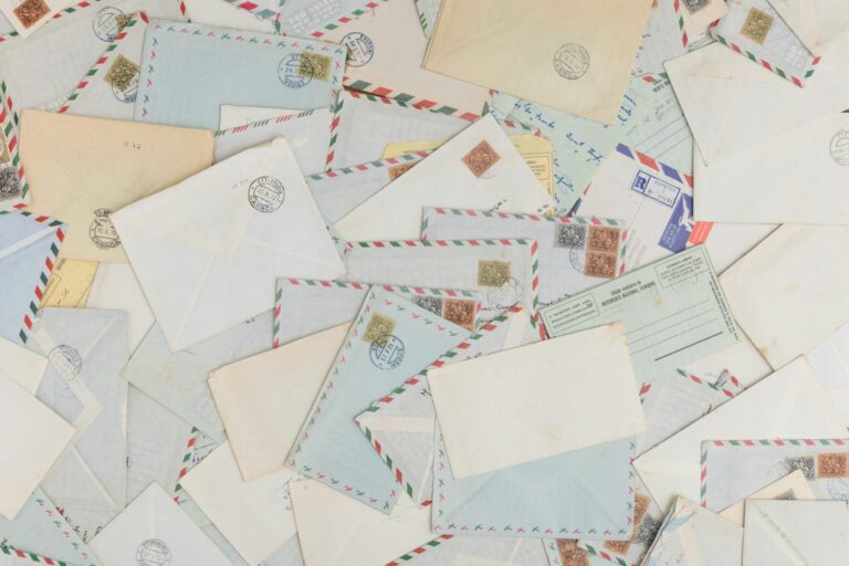 A collection of vintage airmail envelopes and postcards scattered with stamps.