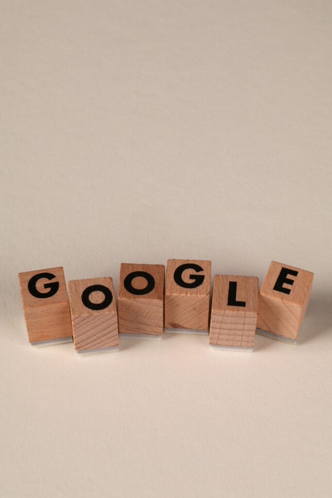 Wooden alphabet blocks forming the word 'Google' on a plain background, arranged playfully.