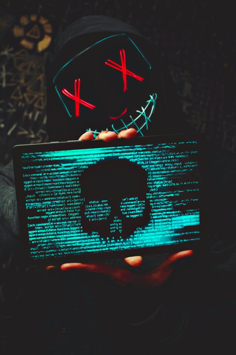 A mysterious person in a neon mask holds a tablet displaying a digital skull.