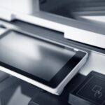 Close-up of a modern printer with a touchscreen interface in a professional office setting.