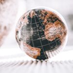 Artistic image of a globe with warm tones, showcasing continents and oceans in close-up view.