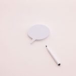 A minimalist speech bubble with a white marker on a clean white background, perfect for creative designs.