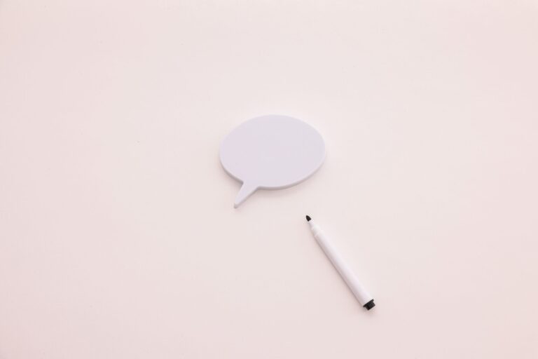 A minimalist speech bubble with a white marker on a clean white background, perfect for creative designs.